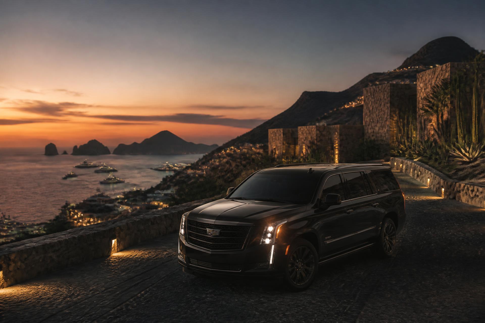 Black luxury SUV overlooking Cabo San Lucas marina at dusk